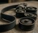 Curea de accesorii uzată și role pentru Renault Kangoo pe o masă de atelier, fotografie clară